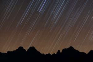 Stars streak across the nocturnal sky over the Cathedral Peak mountain range, an exposure of 32 minutes creating the effect. The warm glow in the sky is created by the very last few rays of astronomical twilight.